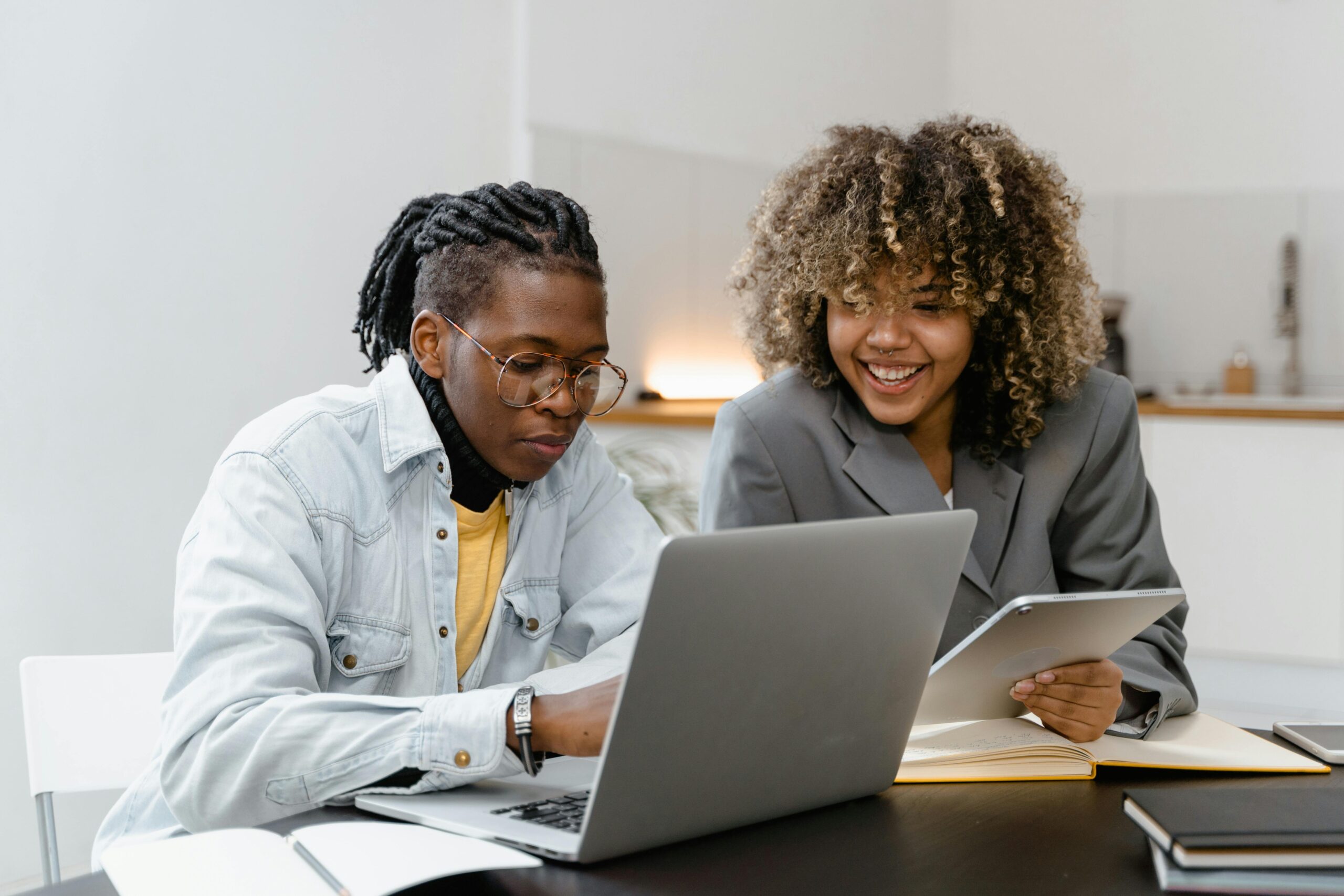 Care Agency improves training compliance. Two people sat at a laptop learning together